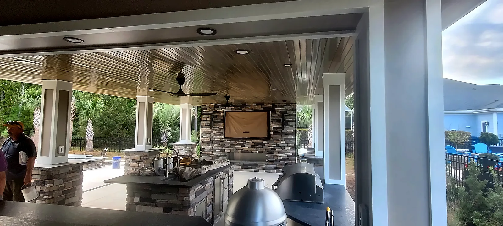 Covered patio with stone outdoor kitchen and ceiling fans