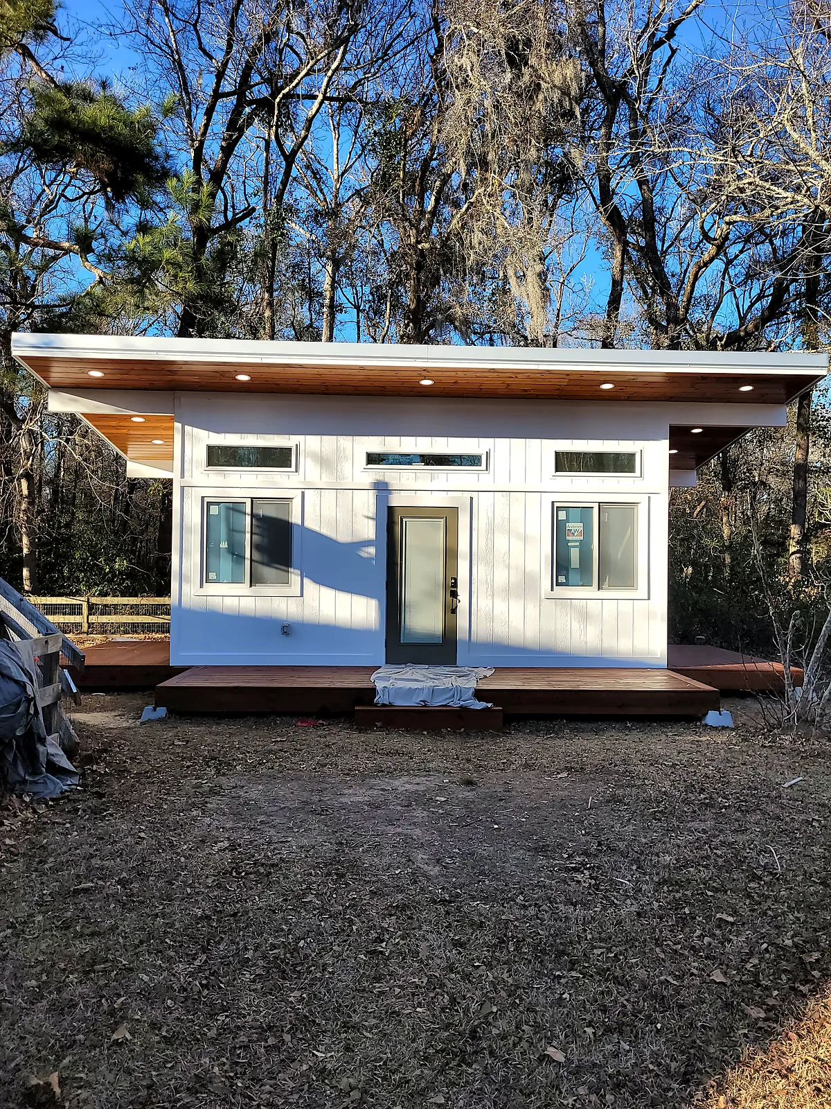 White board-and-batten backyard studio with clerestory windows